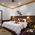 Hotel Harmony in Khajurāho: a cozy guest room with a large bed, bedside lamps, and floral decor.