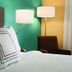 Fairfield Inn & Suites by Marriott South Bend Mishawaka guest room with bed, lamps, and chair
