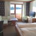 Hotel Geisler Tulfes room with balcony door, mountain view, sofa, and twin beds