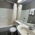 Motel 6 Idabel bathroom with tub-shower combo, vanity sink, toilet, and wall-mounted towels
