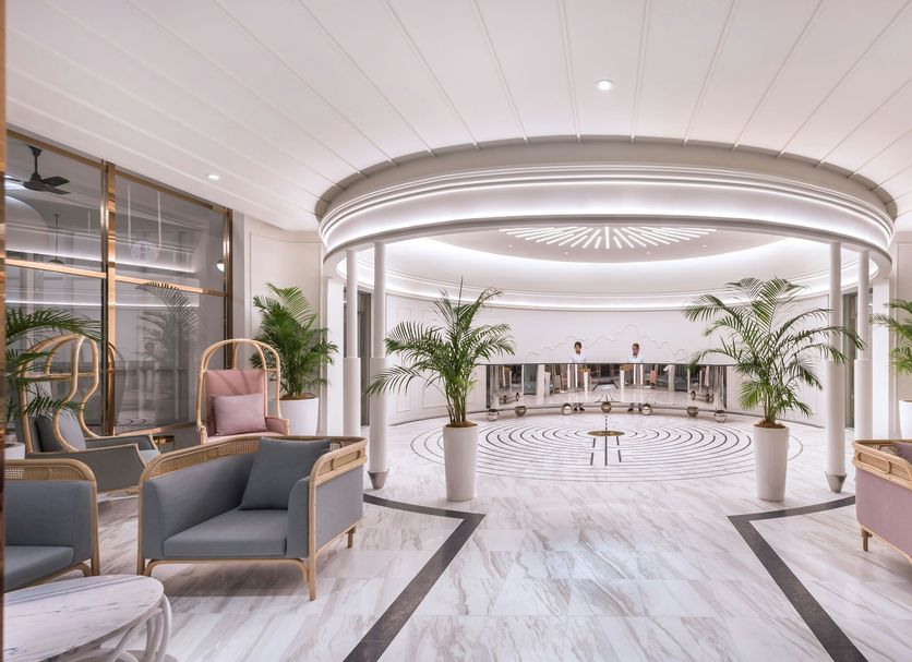 The Prestige Hotel Penang lobby in George Town with curved ceiling, marble floors, and pastel lounge chairs