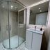 Tumbleweed Cottage in Newark-on-Trent bathroom with curved glass shower enclosure and vanity sink