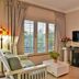 Bellgrove Guest House Sandton in Johannesburg living area with sofa, desk, wall TV, and shutters