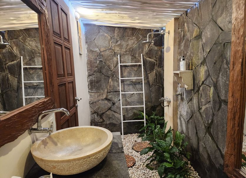 The Calmtree Bungalows North Kuta stone-walled outdoor bathroom with vessel sink and shower