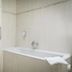Studio's De Vlijt Texel bathroom with bathtub, glass shower enclosure and towel in De Cocksdorp