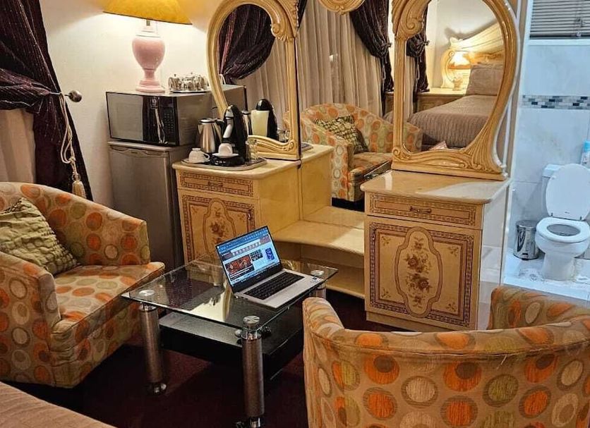 The Royal Princess Garden - Randburg room with ornate vanity, seating area, and glass bathroom enclosure