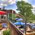The Woodlands Inn in Wilkes-Barre with riverside deck seating, blue umbrellas and a wooded stream view