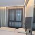 Hotel Eulensteins in Jena guest room with bed, desk, wall-mounted TV and large curtained window