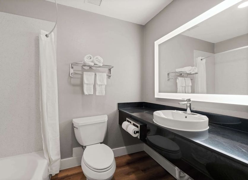 Motel 6 Rosenberg Tx bathroom with shower, toilet, sink and large mirror in Rosenberg