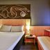 Ibis Goiânia guest room with double bed, bedside lamp, built-in bench and city-view window