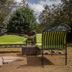 Balis Best Bar and Resort Nairobi outdoor lounge with green cushioned bench and chairs under trees