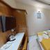 Tr Residency in Pondicherry guest room with double bed, wall-mounted TV, and simple wooden furnishings