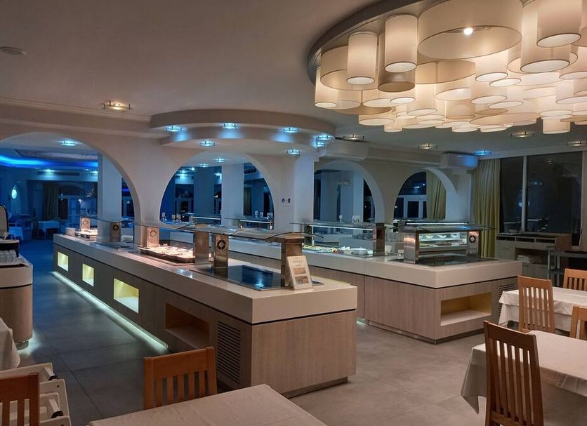 Rethymno Mare & Water Park Rethymno hotel buffet restaurant with modern lighting and arched openings