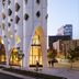 Populus in Denver with distinctive arched facade on a city street at dusk