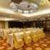 Monarch Plaza Hotel in Taoyuan City banquet room with set tables and gold chair covers
