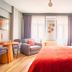 Taks-Inn Suites Istanbul guest room with bed, sofa, dining table, and striped accent wall