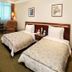 Wuzhou Guest House Shenzhen guest room with two twin beds, seating area and window curtains