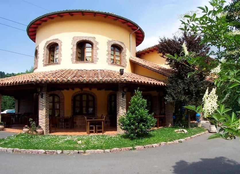 Grupo Hotelero La Pasera in Cangas de Onís, rustic stone hotel exterior with tiled roof and garden
