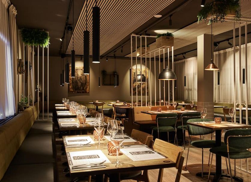 Konvin Hotel by Reykjavik Keflavik Airport restaurant with tables, chairs and pendant lighting in Keflavik