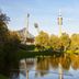 Living Hotel am Olympiapark in Munich with lake reflection, trees, and Olympiapark tower view