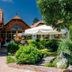Hotel Vineyard Inn in Nagykanizsa with landscaped garden, wooden cottages, and patio umbrella