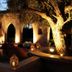 La Maison des Oliviers in Marrakech, lit courtyard with arched openings, seating, and a large olive tree