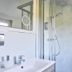 Stössels Hotel in Lüneburg bathroom with sink, mirror, and glass-enclosed shower