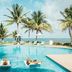 Margaritaville Island Reserve Riviera Cancun in Puerto Morelos with palm-framed oceanfront pool and loungers
