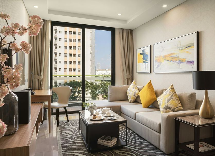 Oakwood Residence Saigon living room with sofa, balcony view, and cityscape in Ho Chi Minh City