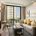 Oakwood Residence Saigon living room with sofa, balcony view, and cityscape in Ho Chi Minh City