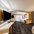Courtyard by Marriott Winston-Salem Downtown guest room with king bed, sofa, desk and wall-mounted TV.