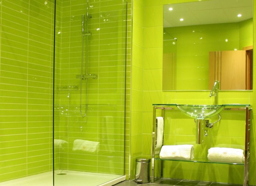 Hotel Indiana in Pinto bathroom with lime green tiles, glass shower, and double sink vanity