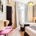 CH Las Murallas Madrid twin guest room with balcony doors, window light, and bedside lamps