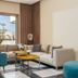 Kenzi Rissani in Errachidia lounge with teal chairs, sectional seating and a window view of palms