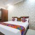Hotel Taj Heritage in Agra: bedroom with double bed, patterned wall, vanity mirror and wardrobe