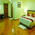Mawlamyine Strand Hotel room in Mawlamyine with bed, TV, desk and polished wood floor