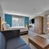 Holiday Inn Express & Suites Portland-Jantzen Beach guest room with bed, sofa, TV, desk and large window