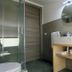 I Giardini della Castellana bathroom with glass shower, round mirror and vanity in Marina di Ragusa