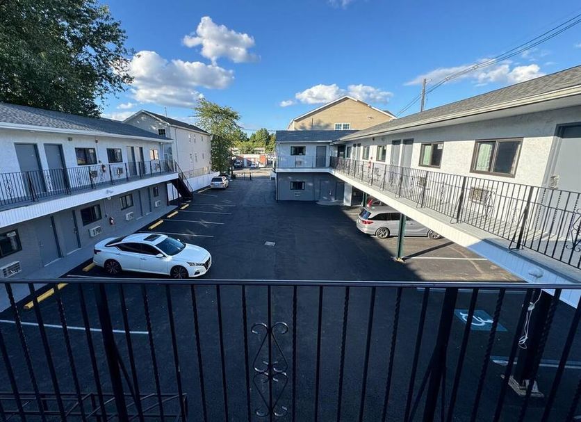 Essence Express Elizabeth Ewr Airport courtyard parking area with two-story motel-style buildings