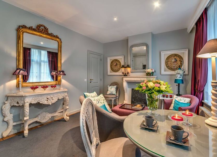 Canalside House - Luxury Guesthouse in Bruges, elegant lounge with fireplace and ornate mirror
