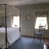 Spread Eagle Tavern and Inn in Hanoverton: four-poster bed in a floral wallpaper guest room with two windows