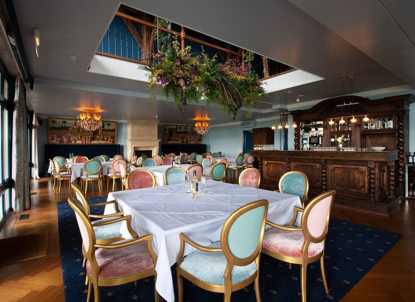Villa Veertien in Dieren dining room with set tables, ornate bar, and skylight greenery