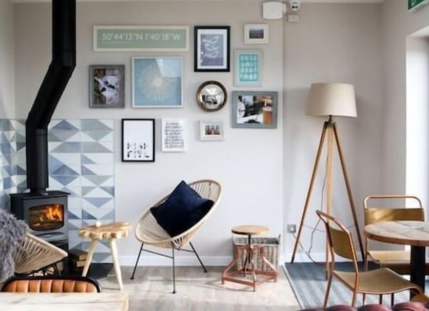 The Cliff House Hotel, New Milton lounge with wood stove, gallery wall, and cozy chairs