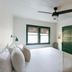 Piety Hill Cottages Nevada City guest room with white bedding, green trim, ceiling fan and adjacent sitting area