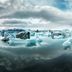 Höfn - Berjaya Iceland Hotels in Hofn with floating icebergs reflected on calm water under cloudy sky