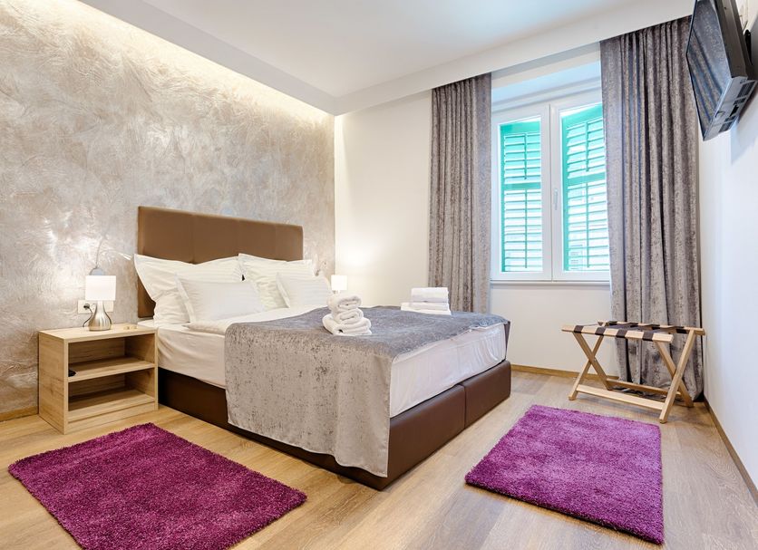 Central Pearl by Nono Ban Rooms Split guest room with bed, window, and purple rugs