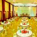 Mawlamyine Strand Hotel banquet hall in Mawlamyine with round tables and stage