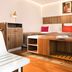 Hotel Eiffel Turenne Paris guest room with bed, wooden desk, chair and framed wall art