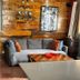Coqui del Mar Guesthouse in San Juan with a cozy lounge, gray sofa, wood walls, and small table