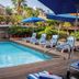 Poolside loungers and blue umbrellas at Hotel Posada De Roger in Puerto Vallarta